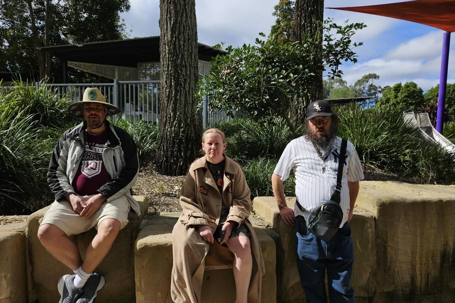 Three participants sitting together in a shaded park